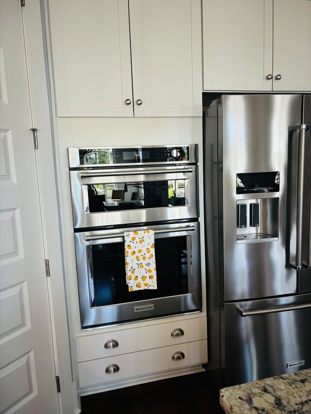 kitchen featuring white cabinets, stainless steel appliances, and light stone countertops