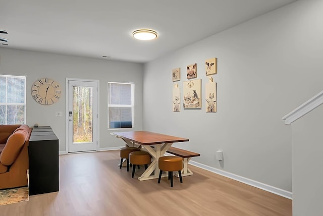 dining area with baseboards and wood finished floors