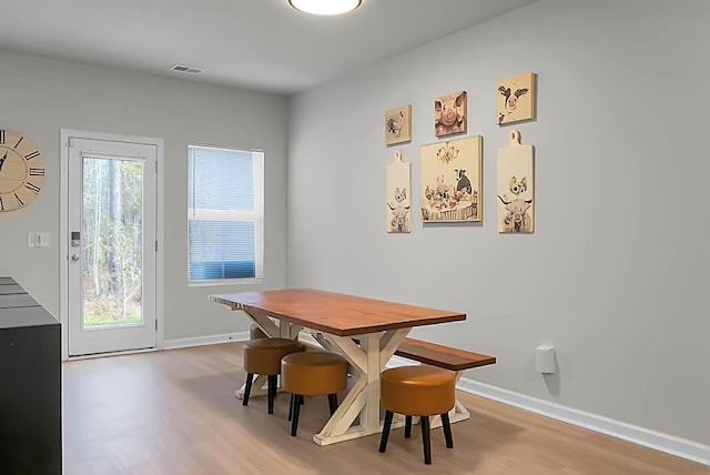 dining space featuring visible vents, baseboards, and wood finished floors