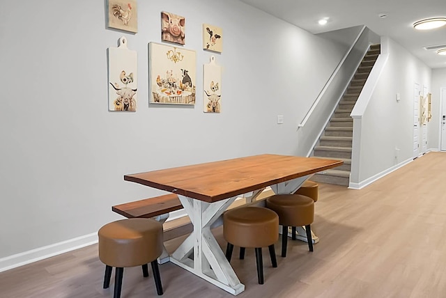 dining area featuring stairs, wood finished floors, and baseboards