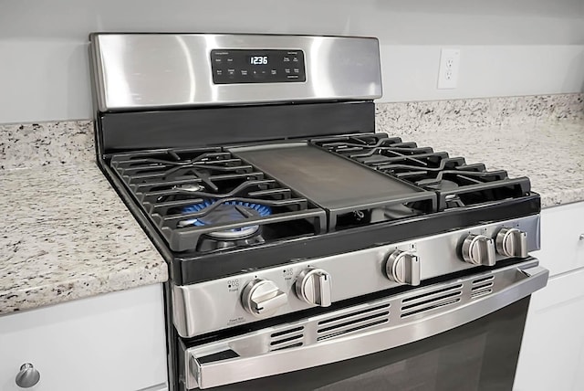 interior details with white cabinetry and stainless steel range with gas stovetop