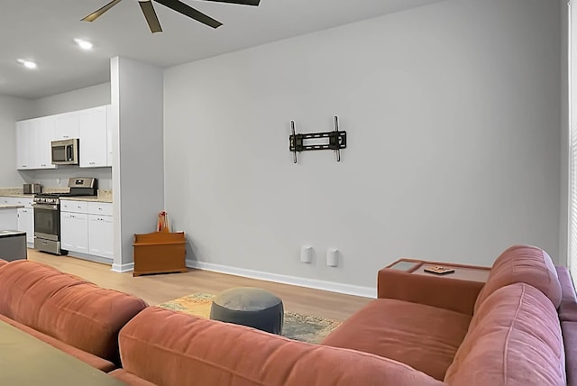 living area featuring baseboards, ceiling fan, recessed lighting, and light wood-style floors