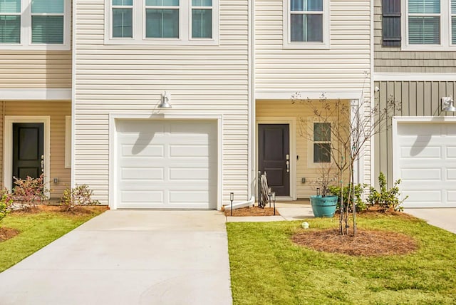 view of exterior entry with a garage and concrete driveway