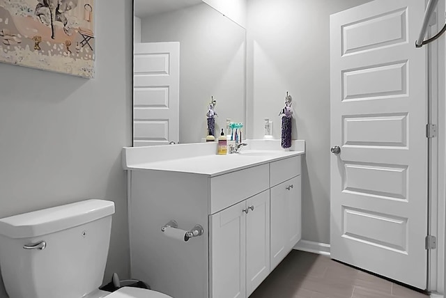 bathroom featuring toilet, vanity, and baseboards