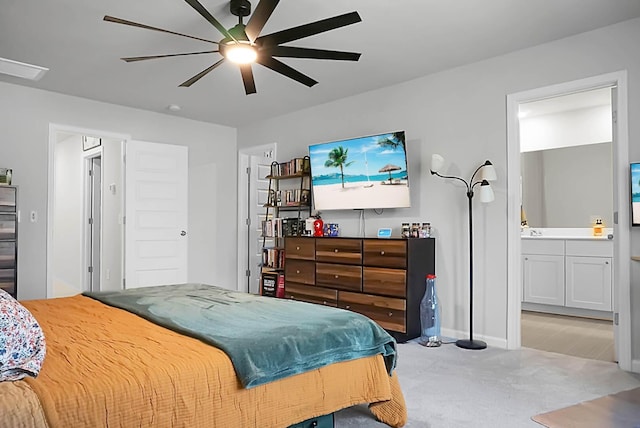 bedroom with a ceiling fan, light colored carpet, and ensuite bathroom