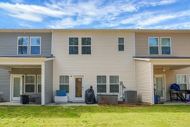 rear view of property featuring ceiling fan, a patio, central AC unit, and a lawn