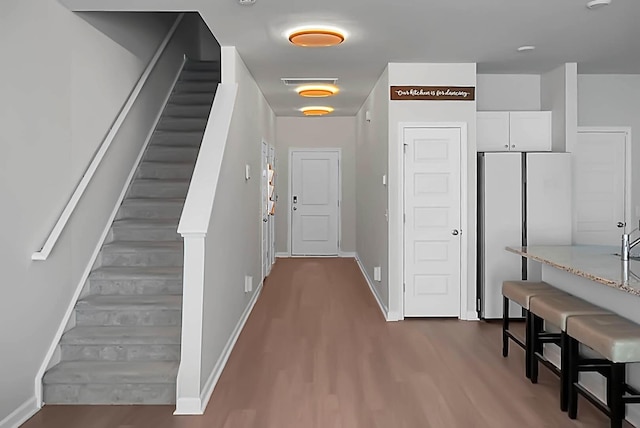 entryway with dark wood-type flooring, visible vents, stairway, and baseboards