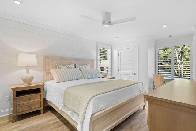 bedroom featuring ceiling fan, wood-type flooring, ornamental molding, and a closet