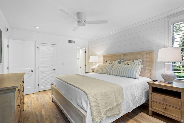 bedroom with hardwood / wood-style floors, multiple windows, crown molding, and ceiling fan