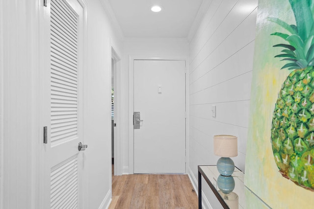 corridor featuring ornamental molding and light hardwood / wood-style flooring