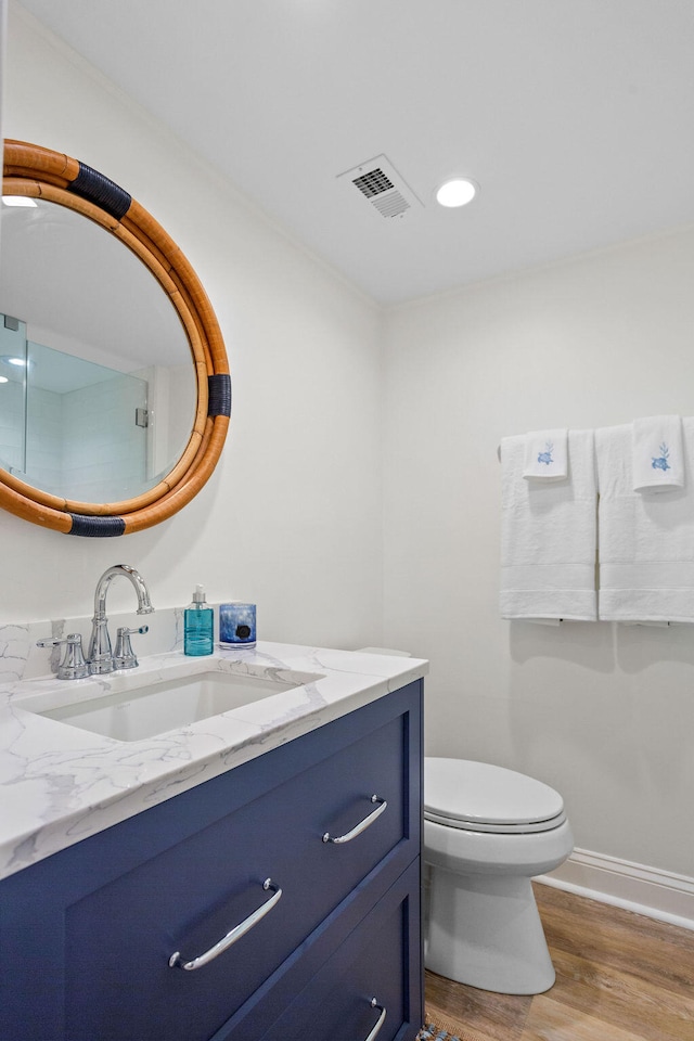 bathroom with hardwood / wood-style flooring, vanity, and toilet