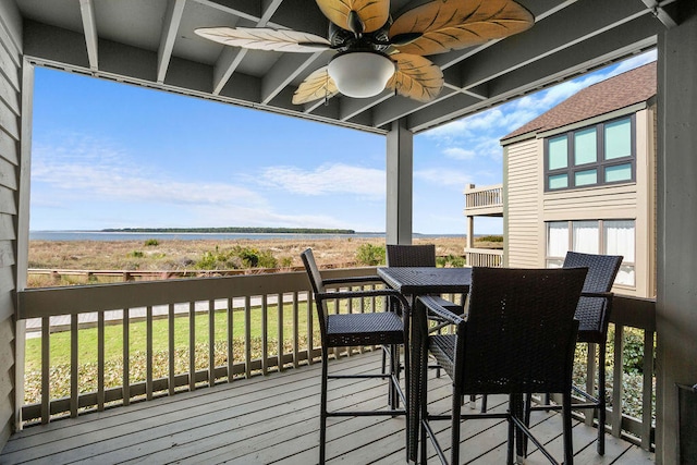 wooden deck featuring a water view and ceiling fan