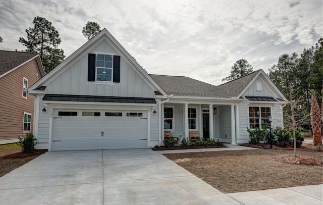 view of front of home with roof with shingles, board and batten siding, a standing seam roof, a garage, and driveway