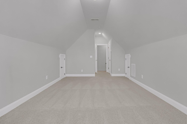 bonus room featuring lofted ceiling, visible vents, light carpet, and baseboards