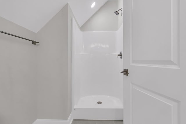 full bathroom with lofted ceiling, tile patterned floors, walk in shower, and baseboards