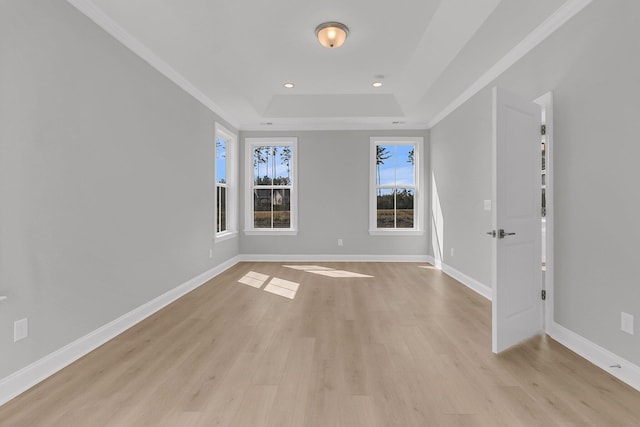 unfurnished room featuring recessed lighting, baseboards, ornamental molding, light wood finished floors, and a raised ceiling