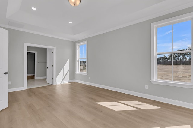 unfurnished room featuring light wood-type flooring, a tray ceiling, baseboards, and recessed lighting