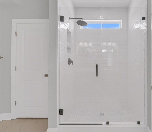 bathroom featuring a stall shower and marble finish floor