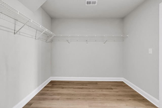 walk in closet featuring visible vents and wood finished floors