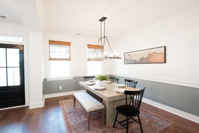 dining area featuring baseboards, dark wood finished floors, visible vents, and an inviting chandelier