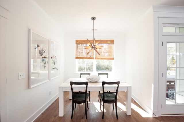 dining area with dark wood-style floors, baseboards, breakfast area, and a notable chandelier