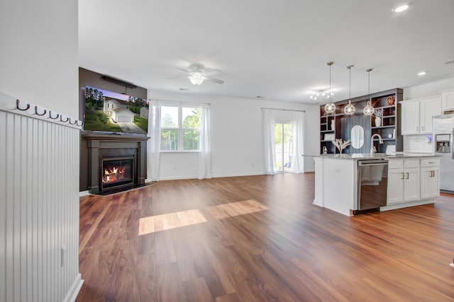 596 Wayton Cir, Moncks Corner, SC 29461 - kitchen with stainless steel appliances, open floor plan, a ceiling fan, a glass covered fireplace, and white cabinetry