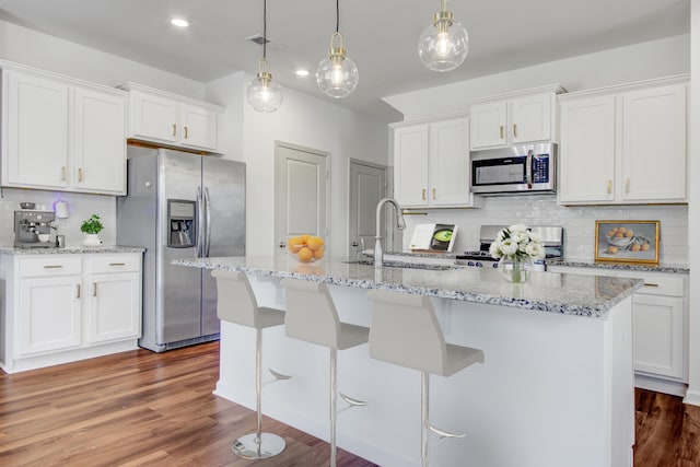 596 Wayton Cir, Moncks Corner, SC 29461 - kitchen featuring appliances with stainless steel finishes, decorative backsplash, a sink, an island with sink, and white cabinets