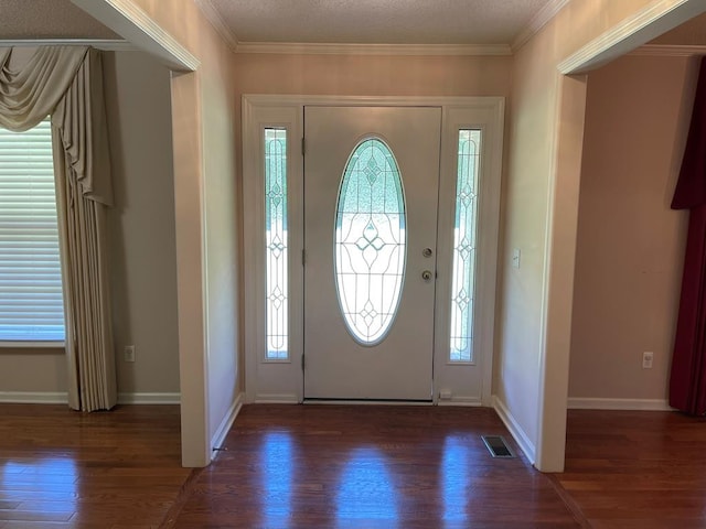 entryway featuring ornamental molding, a textured ceiling, and dark wood-type flooring