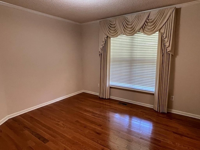 unfurnished room with ornamental molding, dark wood-type flooring, and a textured ceiling