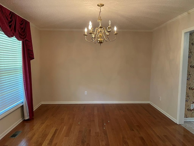 empty room with an inviting chandelier, crown molding, hardwood / wood-style flooring, and a textured ceiling