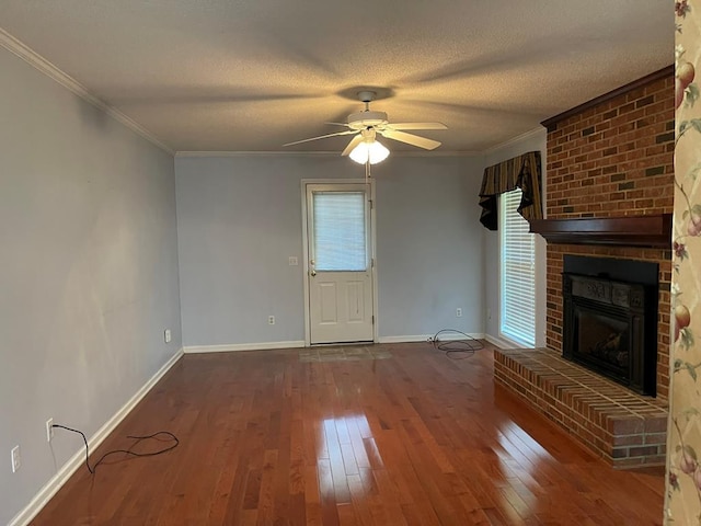 unfurnished living room featuring dark hardwood / wood-style flooring, crown molding, a fireplace, plenty of natural light, and a textured ceiling