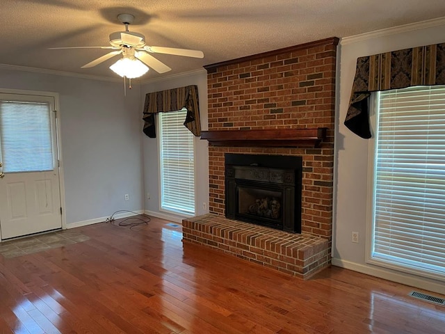 unfurnished living room featuring wood-type flooring, ornamental molding, and a textured ceiling