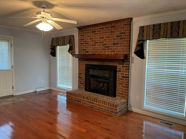 unfurnished living room featuring a fireplace, crown molding, and wood-type flooring