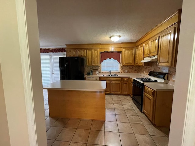 kitchen featuring light tile patterned floors, a wealth of natural light, sink, and black appliances