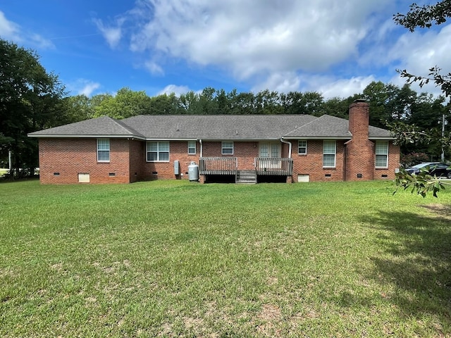 rear view of house featuring a yard and a deck