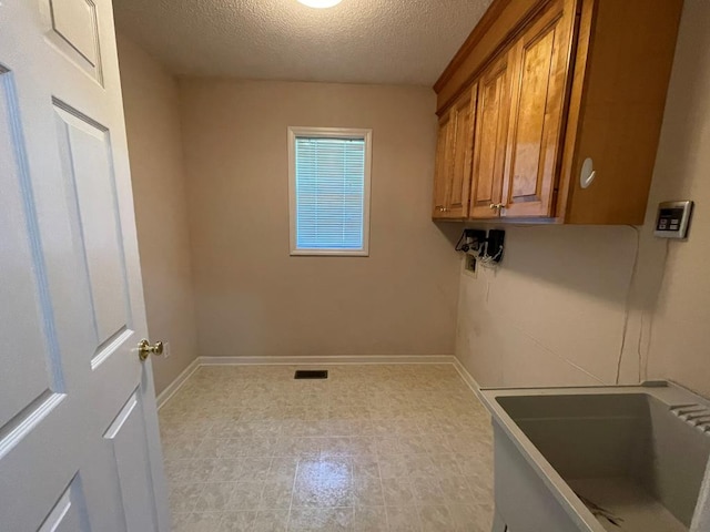 laundry room featuring sink and a textured ceiling