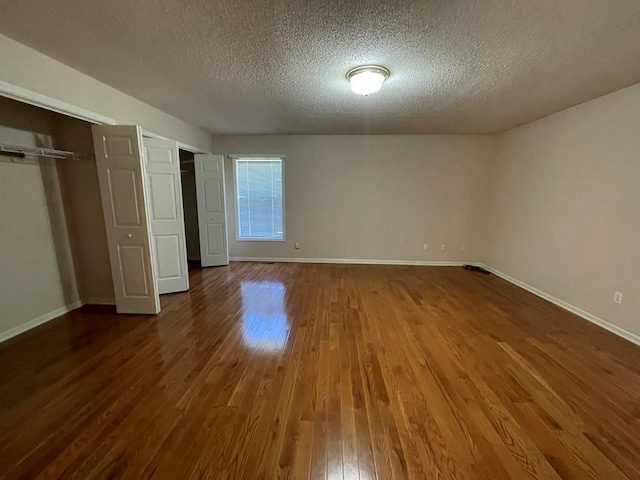 unfurnished bedroom with hardwood / wood-style floors and a textured ceiling