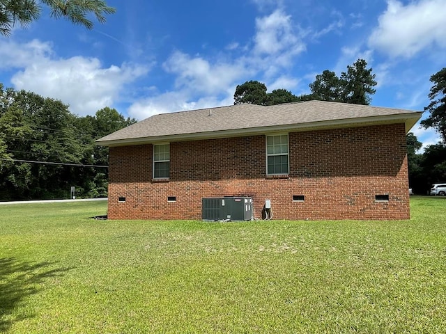 view of home's exterior featuring central AC unit and a yard