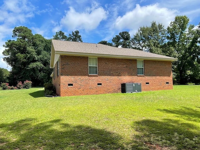 view of side of home with central air condition unit and a lawn