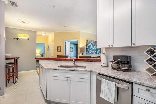 kitchen with pendant lighting, sink, tasteful backsplash, white cabinets, and stainless steel dishwasher