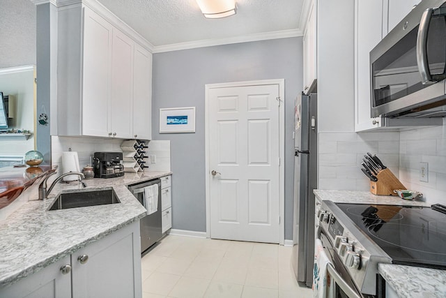 kitchen featuring sink, white cabinetry, ornamental molding, stainless steel appliances, and light stone countertops