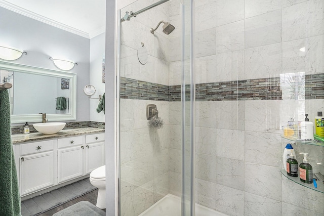 bathroom featuring vanity, crown molding, a shower with shower door, and toilet