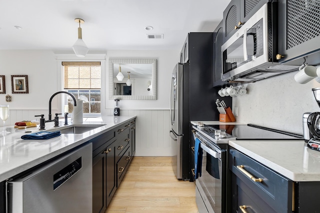 95 Line St, Charleston, SC 29403 - kitchen with a sink, visible vents, appliances with stainless steel finishes, light wood-type flooring, and wainscoting