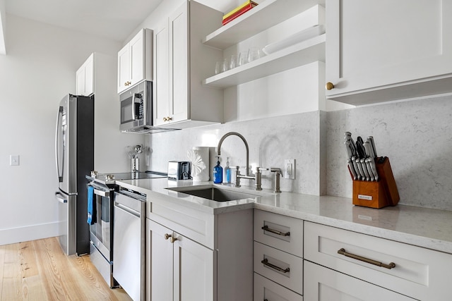 95 Line St, Charleston, SC 29403 - kitchen with tasteful backsplash, appliances with stainless steel finishes, light wood-style floors, open shelves, and a sink