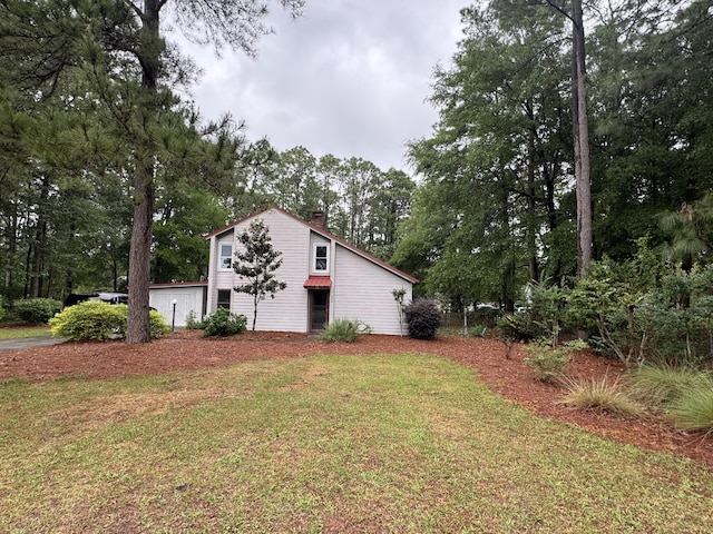 204 Chamblee Rd, Walterboro, SC 29488 - view of home's exterior with a chimney, a yard, and view of wooded area
