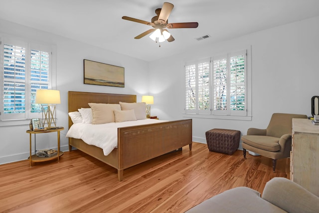 bedroom with multiple windows, ceiling fan, and light hardwood / wood-style floors