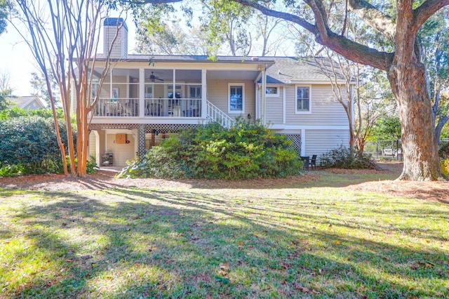 rear view of house with a sunroom and a yard