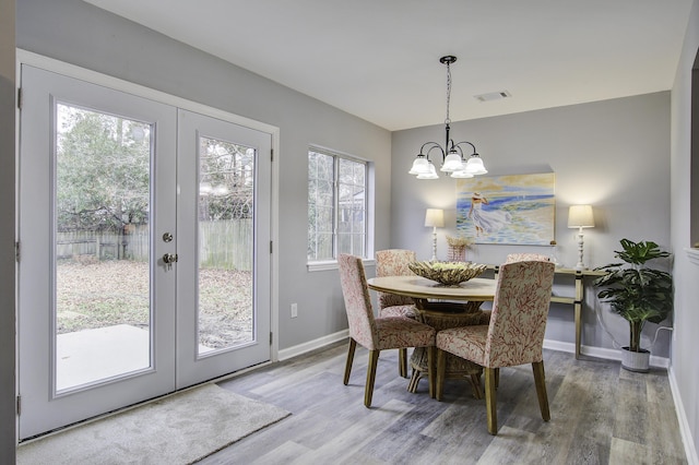 dining room featuring french doors, a chandelier, and hardwood / wood-style floors