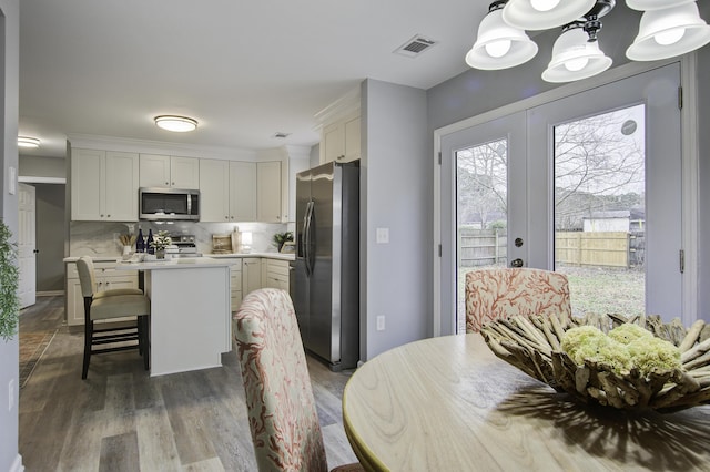 dining space with a notable chandelier, french doors, and dark hardwood / wood-style floors