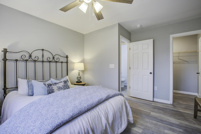 bedroom featuring hardwood / wood-style floors, a closet, ceiling fan, a walk in closet, and ensuite bathroom